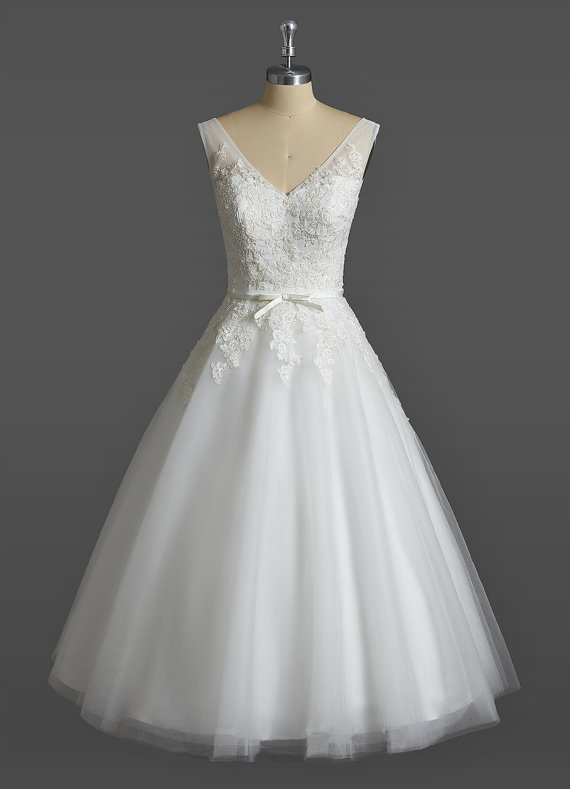Ivory Short Tulle Wedding Gown Featuring Lace Appliqué Sleeveless Plunge V Bodice And Bow Accent Belt